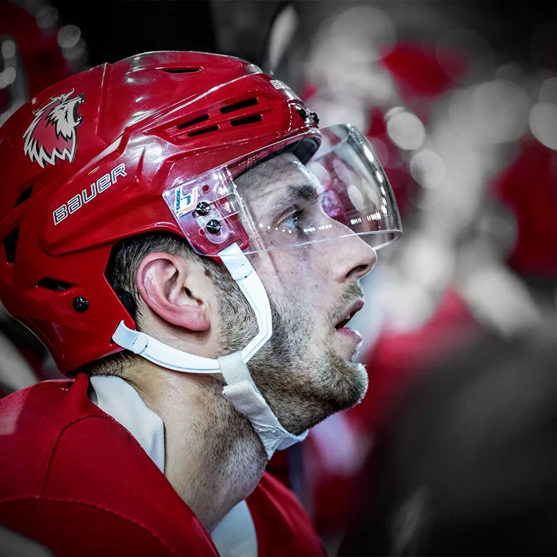 Joueur du LHC de profil, casque rouge et visière, regard concentré