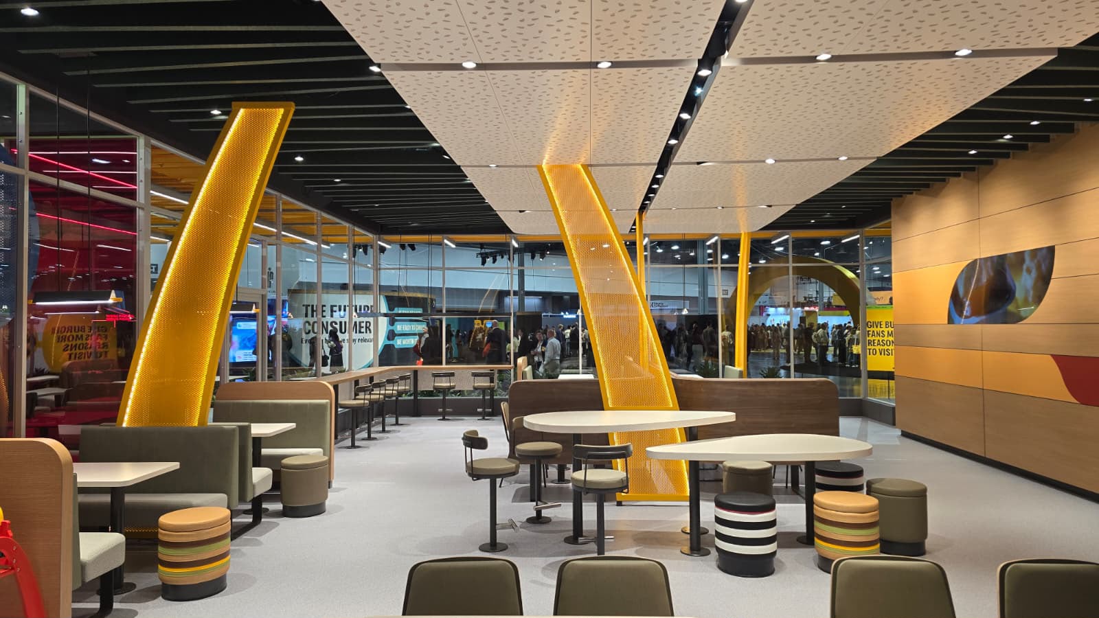L'intérieur du restaurant concept : mobilier chaleureux, arches lumineuses et messages sur le consommateur de demain