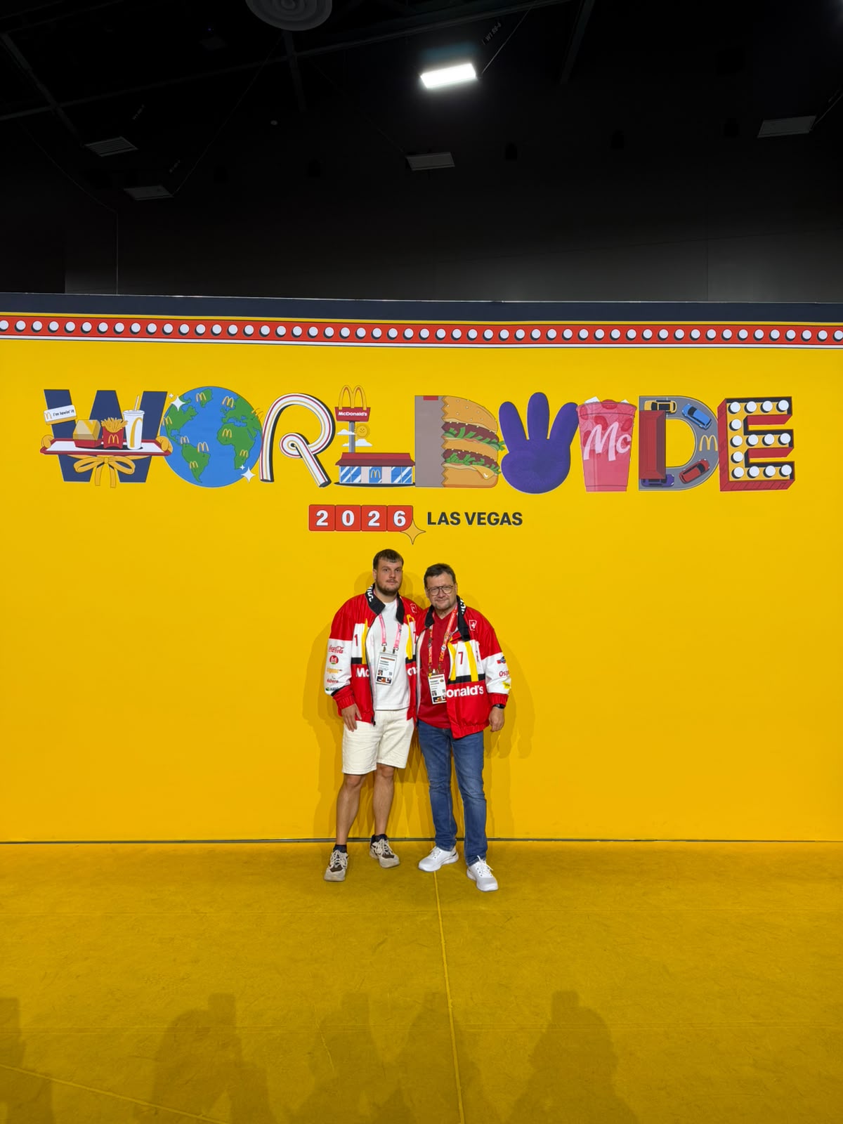 Deux participants en maillots McDonald's devant le mur Worldwide 2026 Las Vegas